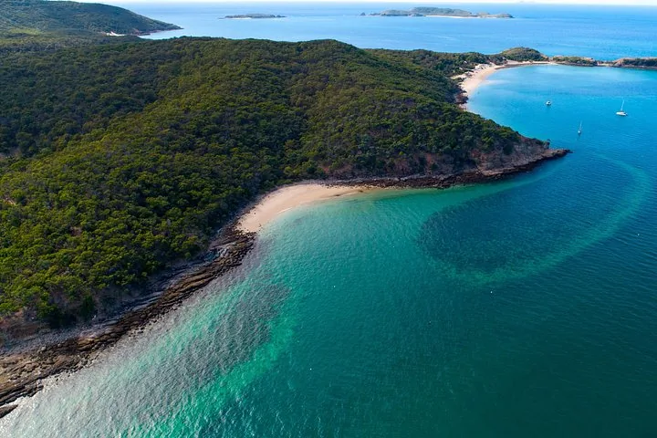 Vista aérea de una isla con una hermosa playa y el océano que la rodea.